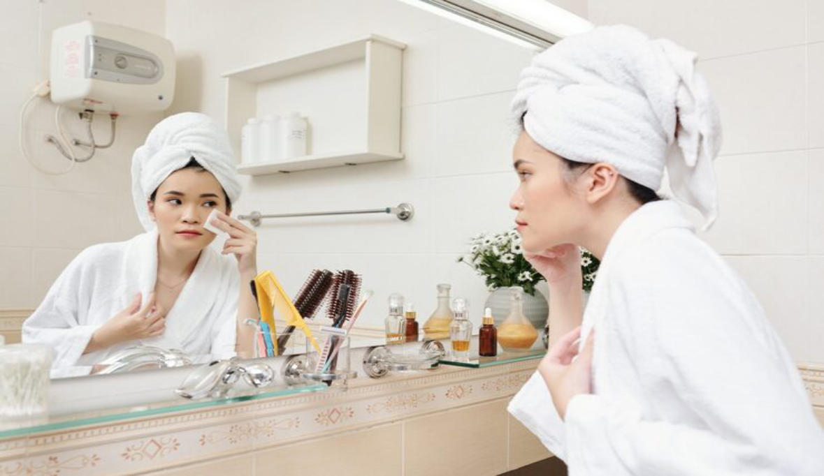 Woman applying brightening hydrating toner face with cotton pad