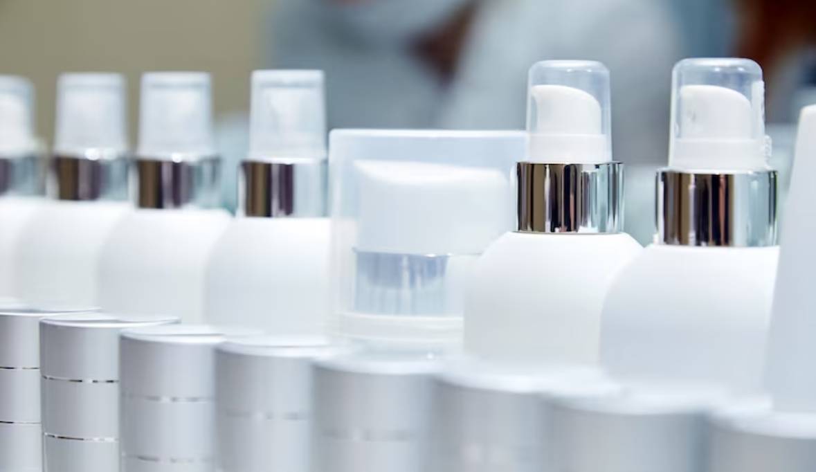 Row white blank bottles with cosmetic products