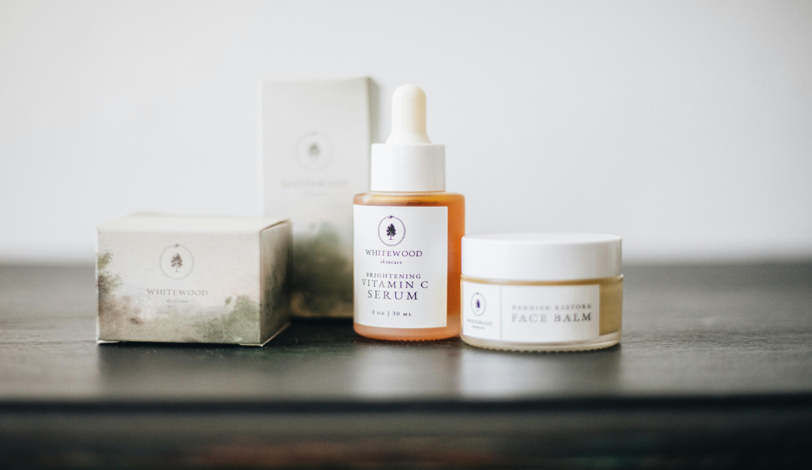 Three skincare products on a dark surface