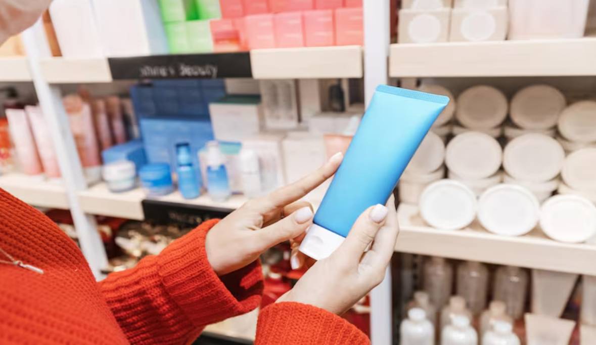 Woman customer chooses buys cosmetics tube moisturizing cream lotion