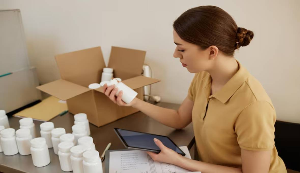 Woman holding blank pill bottle doing quality control factory