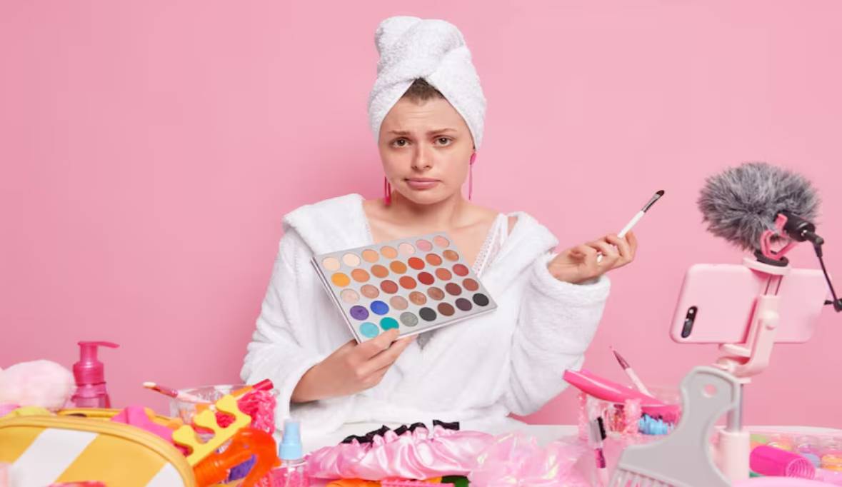 Woman white bathrobe towel holds eyeshadow palette cosmetic brush